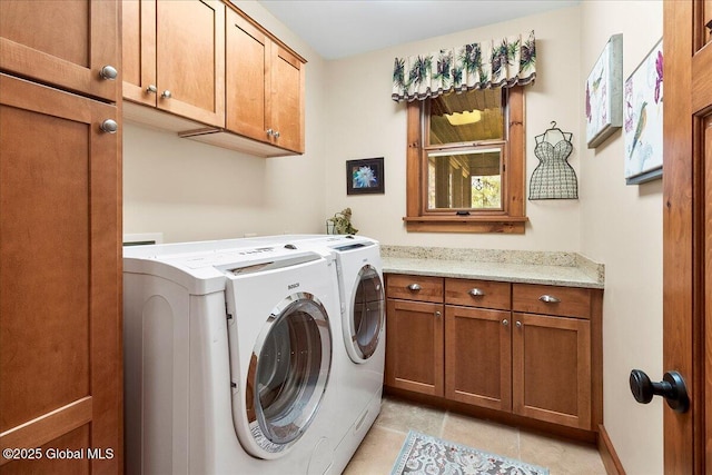 laundry area with cabinet space, washing machine and dryer, and light tile patterned floors