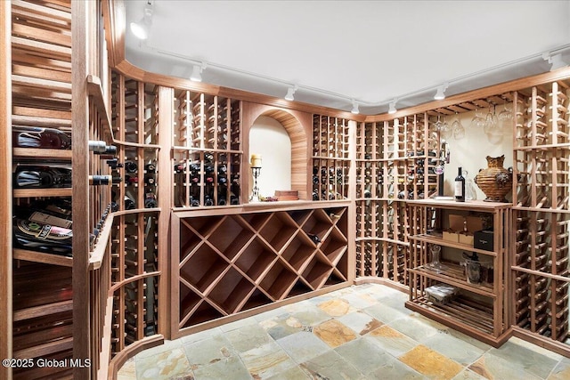 wine room with rail lighting and stone finish floor