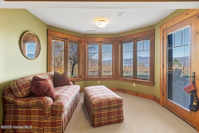 sitting room featuring light carpet and baseboards
