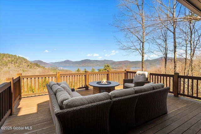wooden terrace featuring an outdoor living space with a fire pit and a mountain view