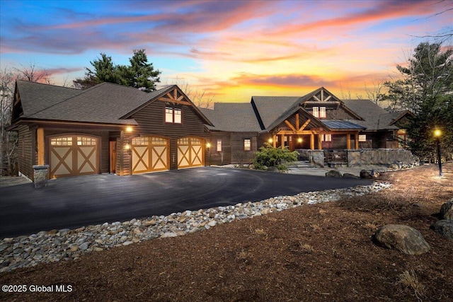 view of front of home with a porch, driveway, and a garage