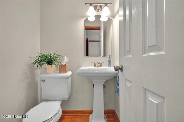 half bathroom with wood finished floors and toilet