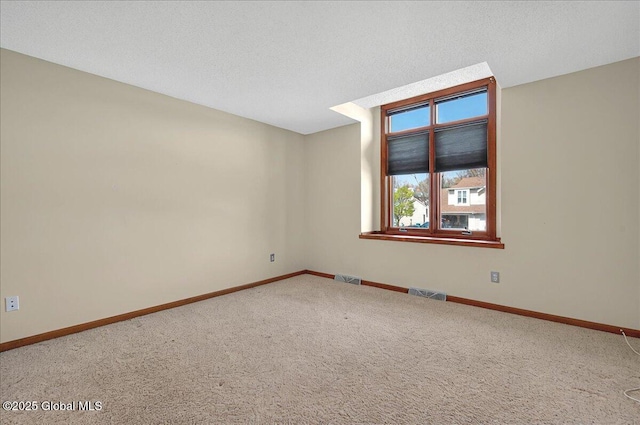 carpeted empty room with visible vents and baseboards