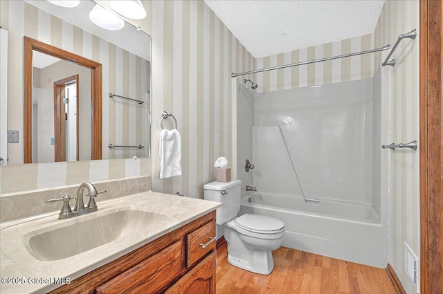 full bath with vanity, visible vents, wood finished floors, toilet, and bathtub / shower combination
