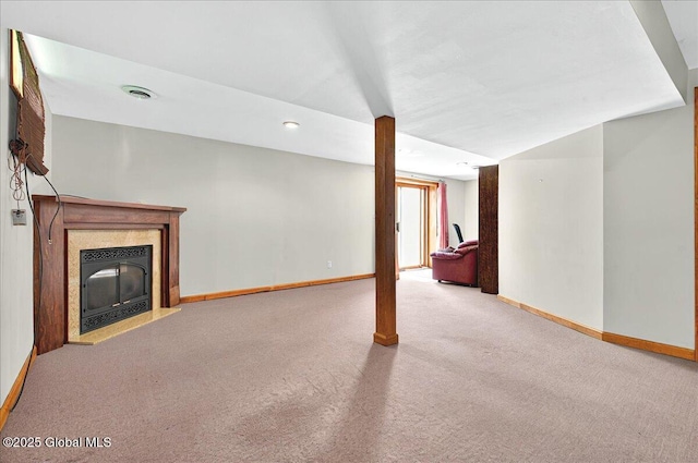 unfurnished living room with carpet flooring, a premium fireplace, baseboards, and visible vents