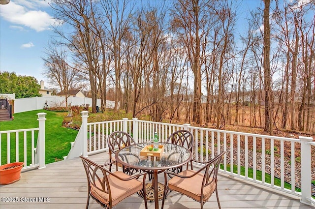 wooden terrace featuring fence, outdoor dining space, and a yard