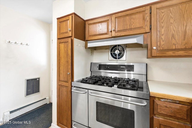 kitchen with light countertops, under cabinet range hood, a baseboard heating unit, brown cabinets, and double oven range