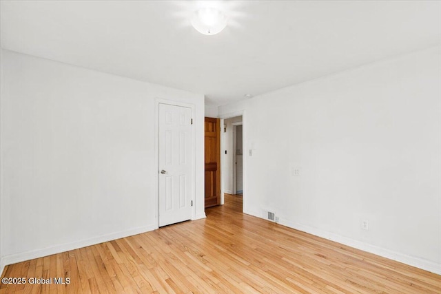 unfurnished room featuring light wood-style floors, baseboards, and visible vents