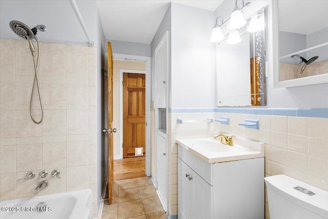 full bath featuring vanity, toilet, tile walls, shower / bathing tub combination, and tile patterned floors