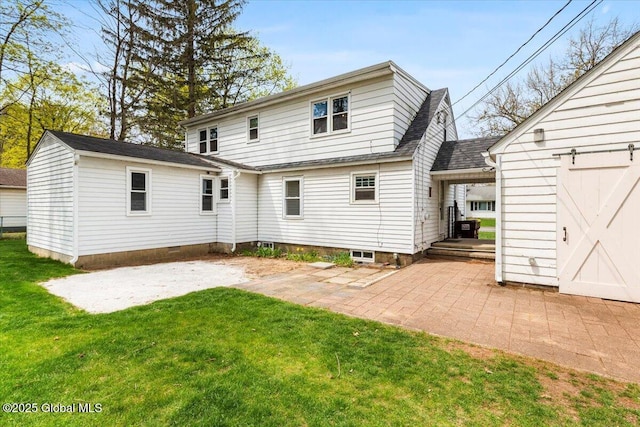 rear view of property featuring a yard, a patio, and roof with shingles