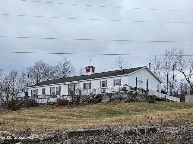 view of front of home with a front yard and a deck