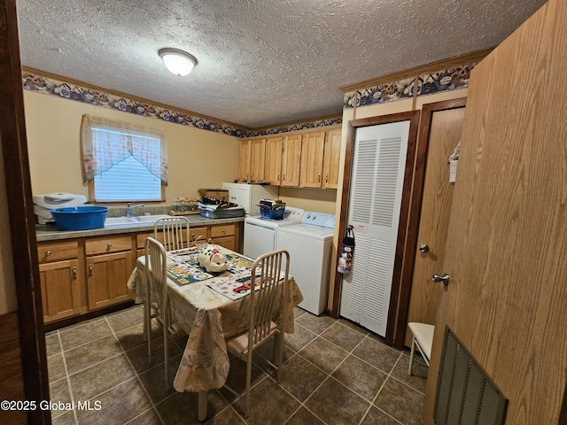 laundry area featuring a textured ceiling, visible vents, cabinet space, and washing machine and dryer