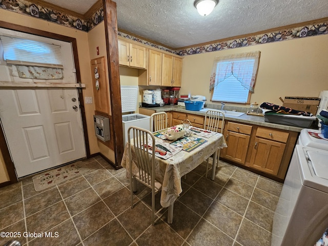 kitchen featuring heating unit, a textured ceiling, washer and clothes dryer, and a sink