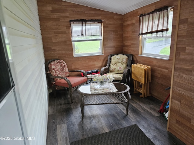 sitting room with wood finished floors, wooden walls, and vaulted ceiling