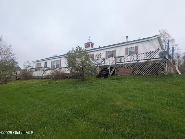 rear view of property featuring a yard and a wooden deck