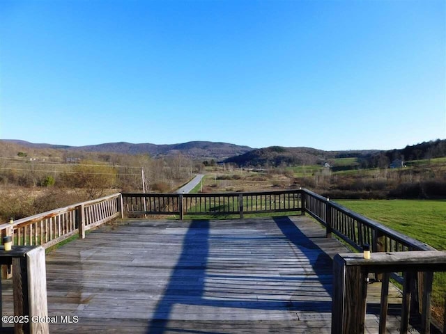 deck with a rural view and a mountain view