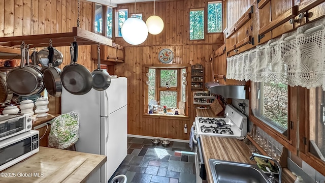 185 Old Schroon Rd, Schroon, NY 12870 - kitchen with stone tile floors, a sink, wooden walls, butcher block countertops, and white appliances