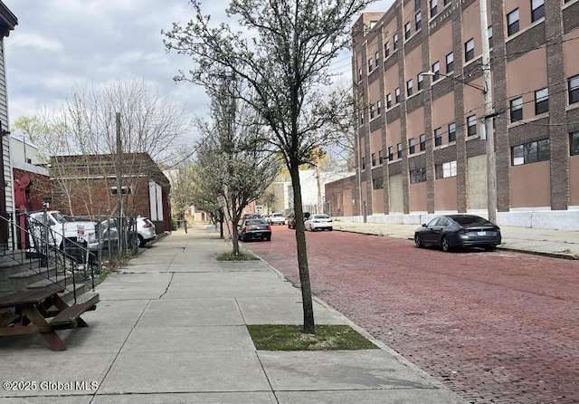 view of road featuring curbs, sidewalks, and street lights