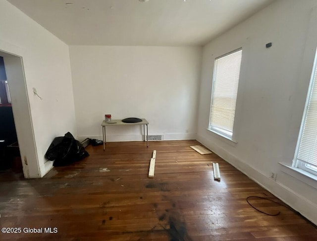 unfurnished dining area featuring visible vents, hardwood / wood-style floors, and baseboards