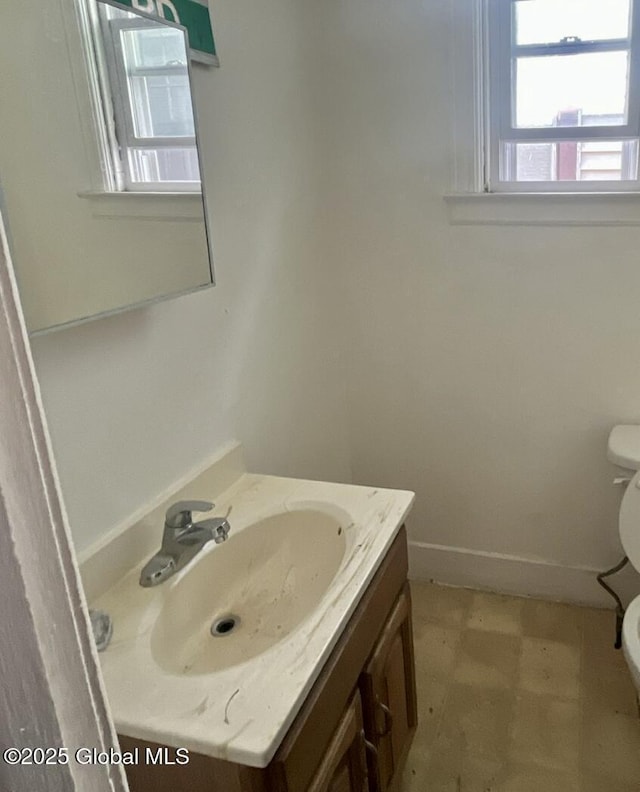 bathroom featuring tile patterned floors, toilet, vanity, and baseboards