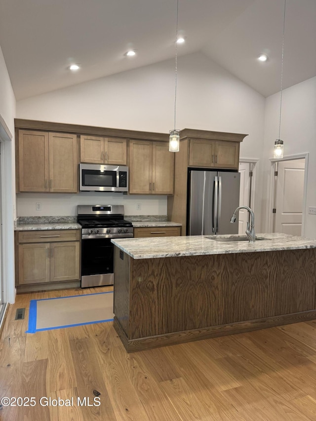 2 Birch Dr, Moreau, NY 12828 - kitchen with appliances with stainless steel finishes, vaulted ceiling, light wood-type flooring, decorative light fixtures, and light stone counters
