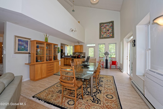 107 Wilderness Way, Stephentown, NY 12169 - dining room with high vaulted ceiling, a baseboard radiator, and light wood-type flooring