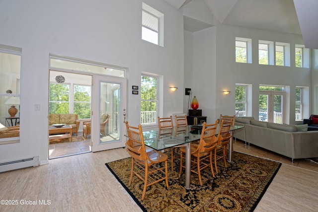 107 Wilderness Way, Stephentown, NY 12169 - dining area featuring a towering ceiling, wood finished floors, a baseboard radiator, and french doors