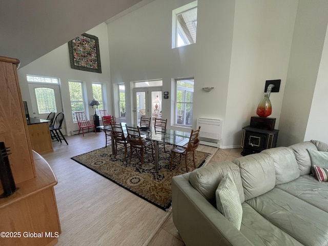 107 Wilderness Way, Stephentown, NY 12169 - dining room featuring a wood stove, a high ceiling, and light wood-style flooring