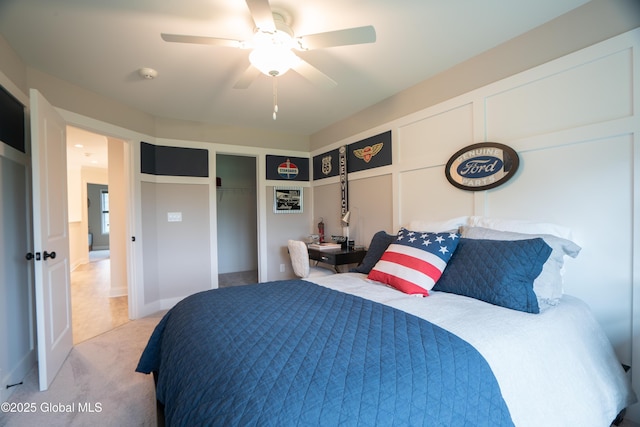 bedroom featuring light colored carpet, a ceiling fan, and a closet
