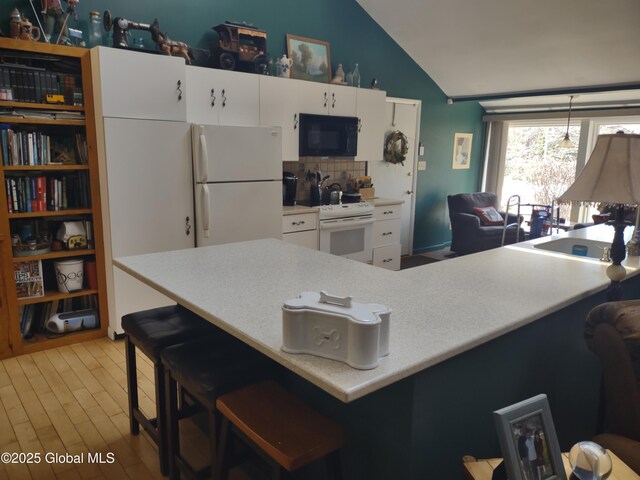 1486 County Highway 112, Caroga, NY 12032 - kitchen featuring light countertops, white cabinets, vaulted ceiling, and white appliances