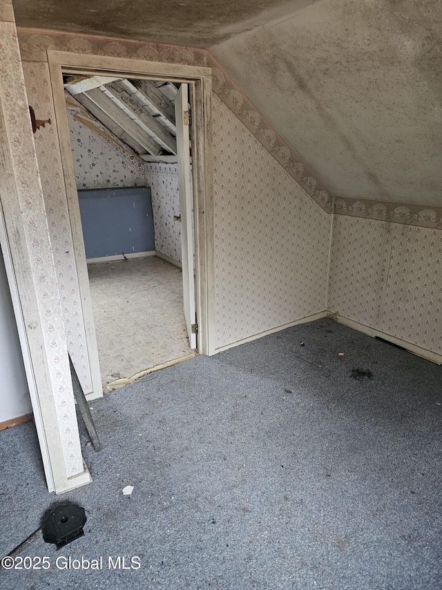 bonus room with wallpapered walls, carpet floors, and lofted ceiling