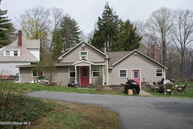craftsman inspired home featuring a chimney and a front lawn