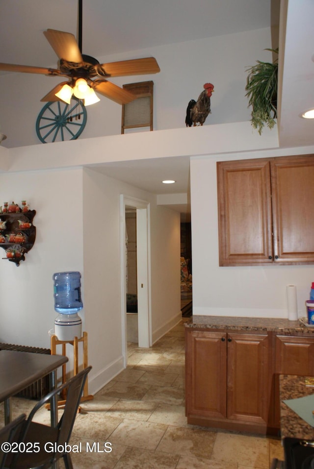 kitchen with recessed lighting, ceiling fan, stone finish floor, and brown cabinetry