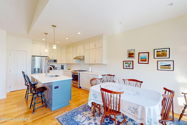 dining area with baseboards, recessed lighting, and light wood-style flooring