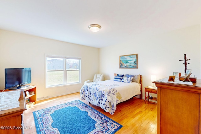 bedroom with visible vents, light wood-style flooring, and baseboards