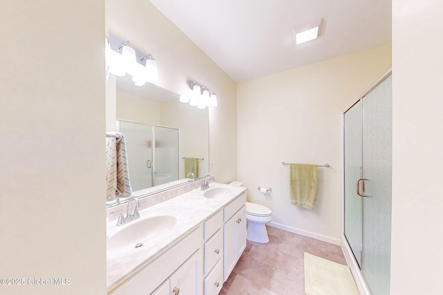 bathroom with a sink, a stall shower, toilet, and double vanity
