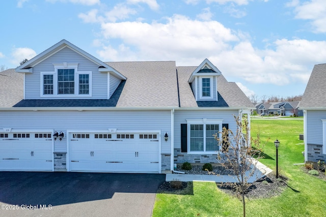 view of front of home featuring aphalt driveway, stone siding, a front yard, roof with shingles, and an attached garage