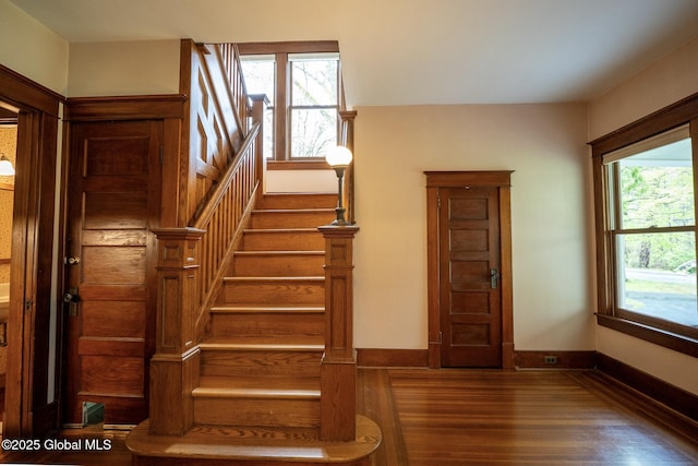 stairs featuring wood finished floors and baseboards