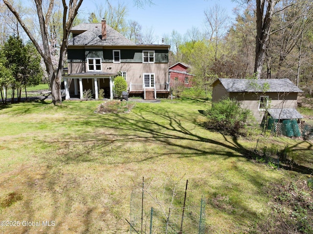 back of house with a yard, a chimney, and a wooden deck