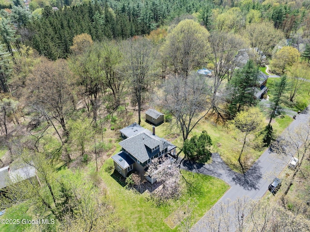 aerial view of property and surrounding area featuring a heavily wooded area