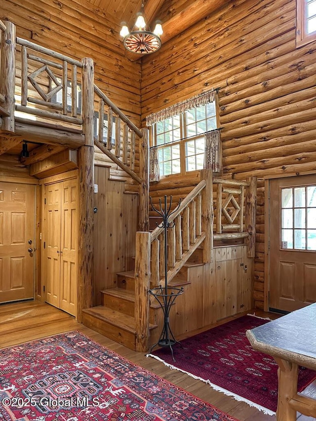 25 Birch Dr, Bolton, NY 12824 - staircase featuring a high ceiling, rustic walls, and wood finished floors