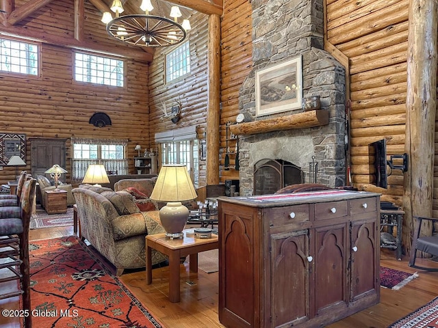 25 Birch Dr, Bolton, NY 12824 - living area featuring a towering ceiling, rustic walls, light wood-style floors, a chandelier, and a stone fireplace