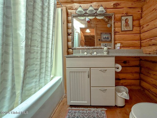 25 Birch Dr, Bolton, NY 12824 - bathroom with rustic walls, shower / bath combo with shower curtain, vanity, wood finished floors, and toilet