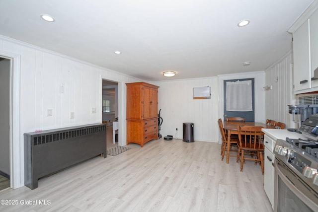kitchen with crown molding, radiator heating unit, light wood-style flooring, stainless steel range with gas cooktop, and recessed lighting