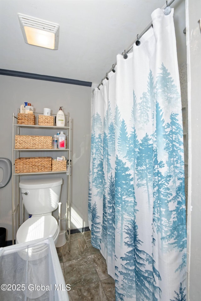 full bath featuring toilet and baseboards