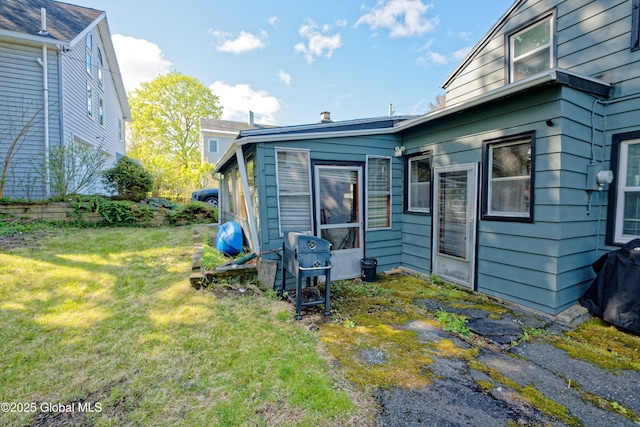 rear view of house featuring a lawn