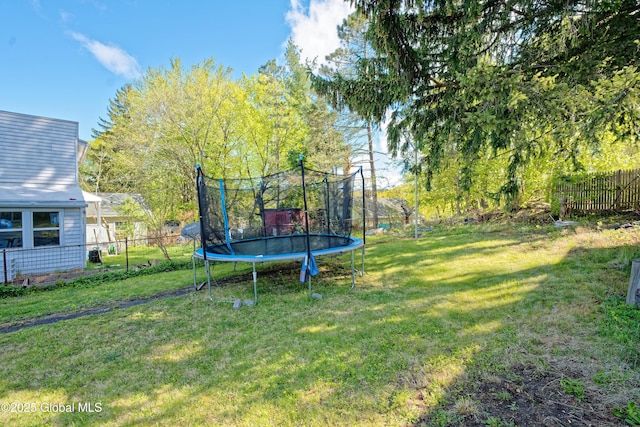 view of yard featuring fence private yard and a trampoline
