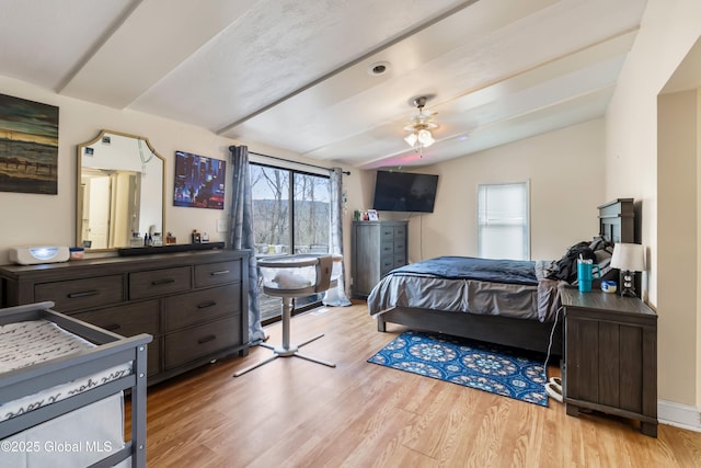 bedroom featuring ceiling fan, light wood-style flooring, and lofted ceiling