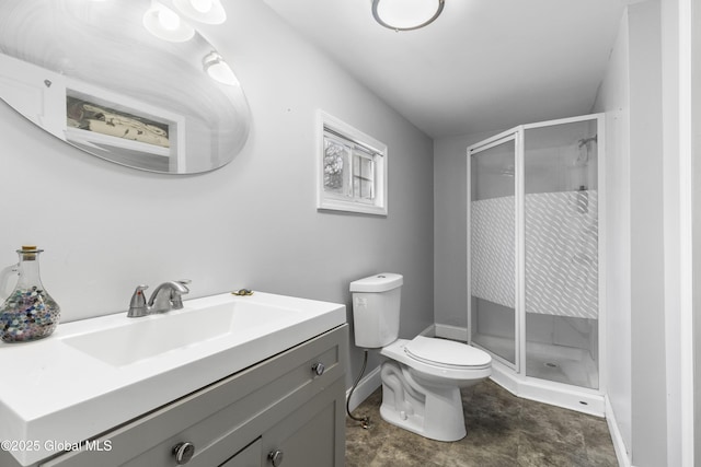 bathroom featuring baseboards, a stall shower, toilet, and vanity