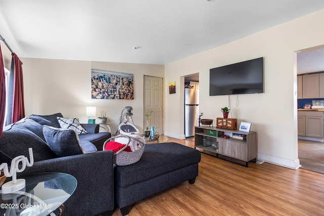 living area with light wood-style floors and baseboards